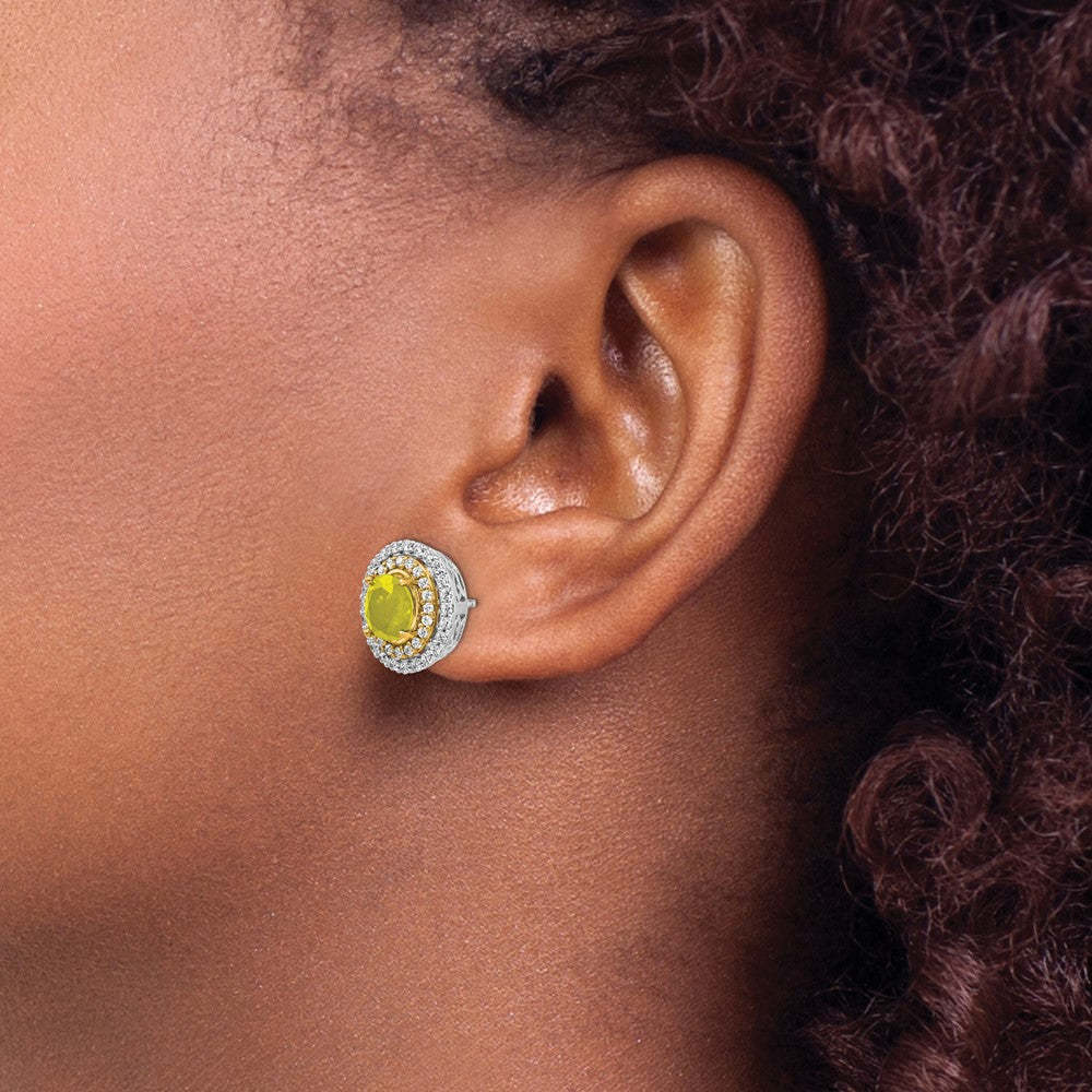 Close-up of an ear wearing a yellow gemstone earring with a silver halo.
