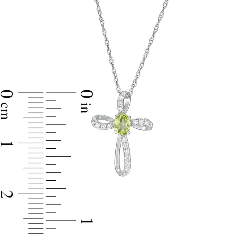 Oval Peridot and 0.1 CT. T.W. Natural Diamond Pinwheel Cross Pendant in 10K White Gold