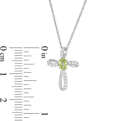 Oval Peridot and 0.1 CT. T.W. Natural Diamond Pinwheel Cross Pendant in 10K White Gold